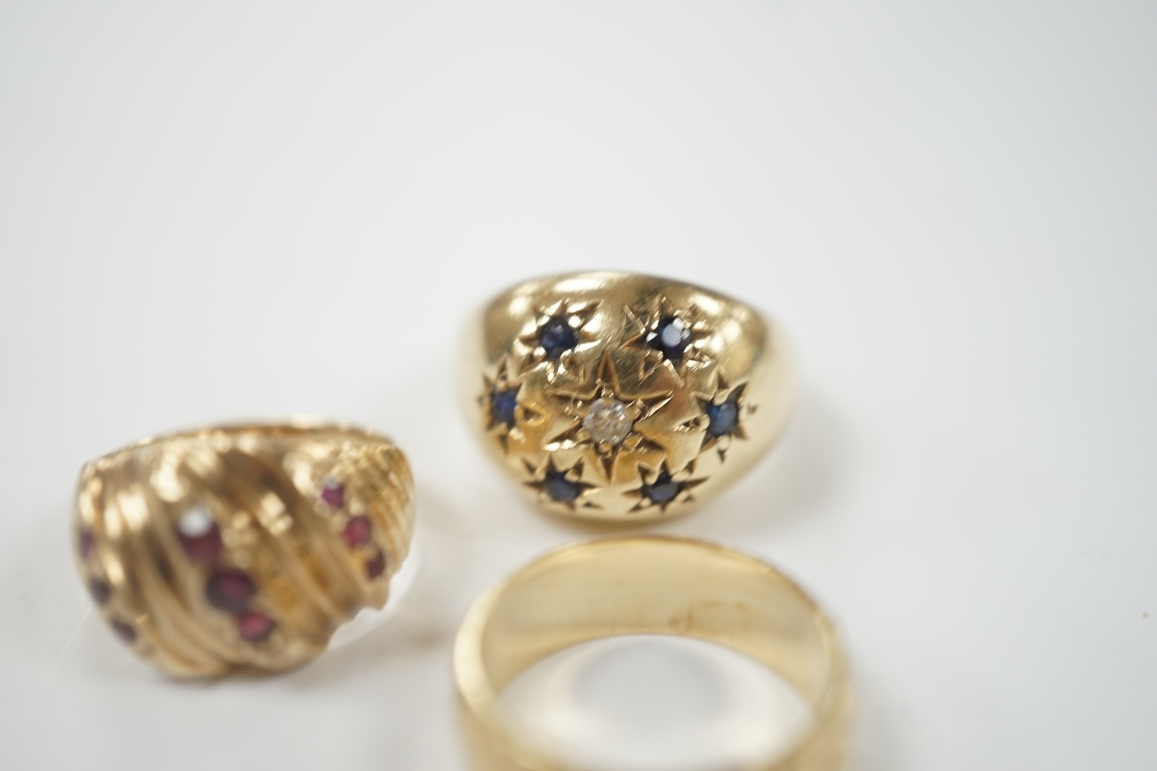 Two modern 9ct gold and gem set dress rings and a similar engraved 9ct gold band